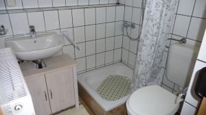 Im Badezimmer gibt es eine Dusche, ein WC, ein Waschbecken sowie einen Spiegelschrank. - Bild 8: Ferienwohnung (Souterrain) in Berlin-Rudow